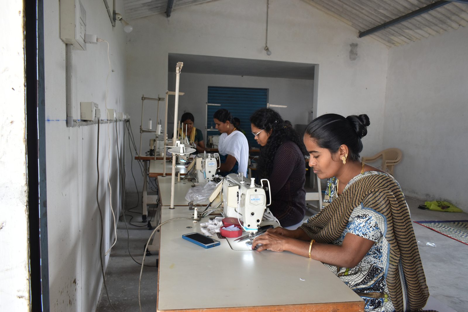 Women at work in a tailoring unit set up through an NMCT skills programme